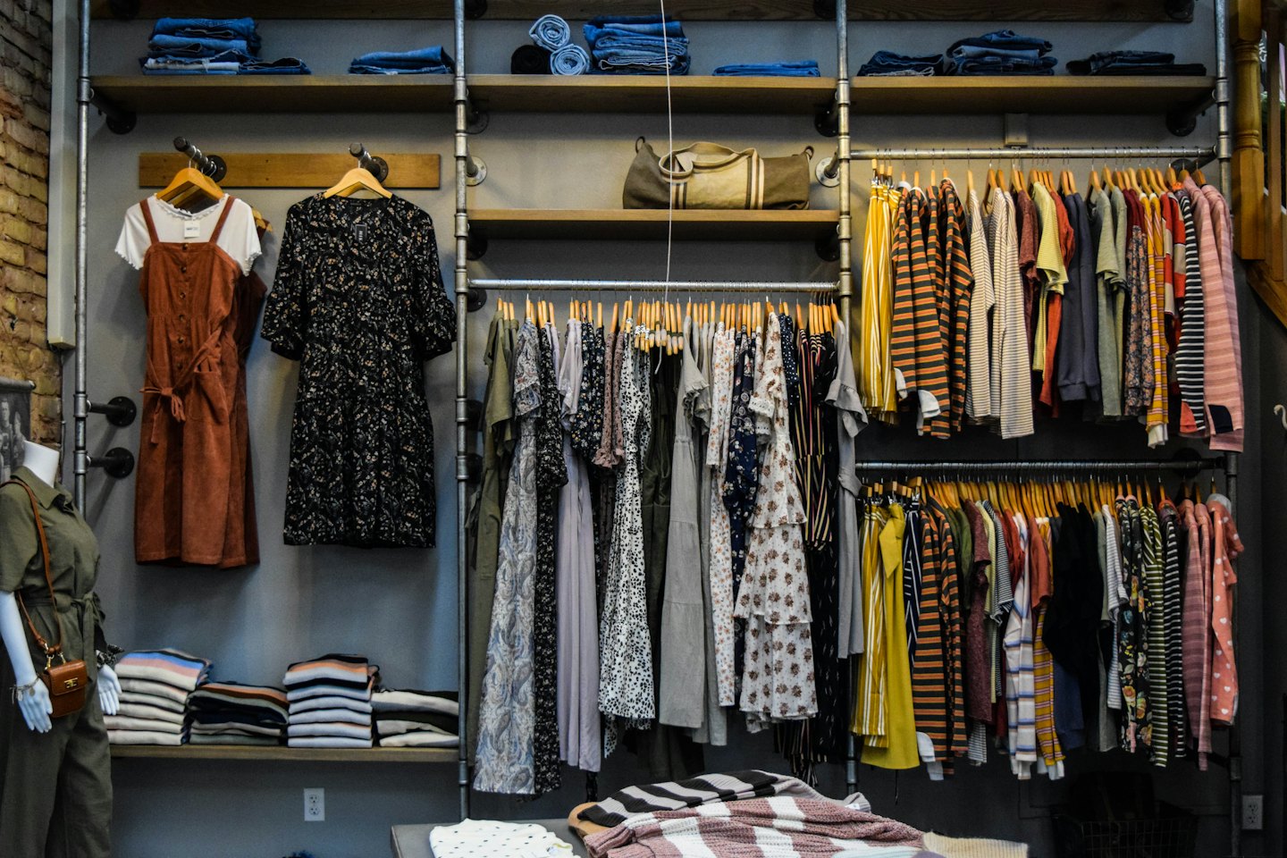 Butik z odzieżą damską z sukienkami i kombinezonami na wystawie.